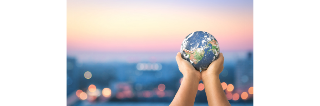 Human hand holding earth globe over blurred city night background.