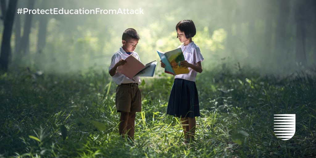 Two children reading a books in a forest