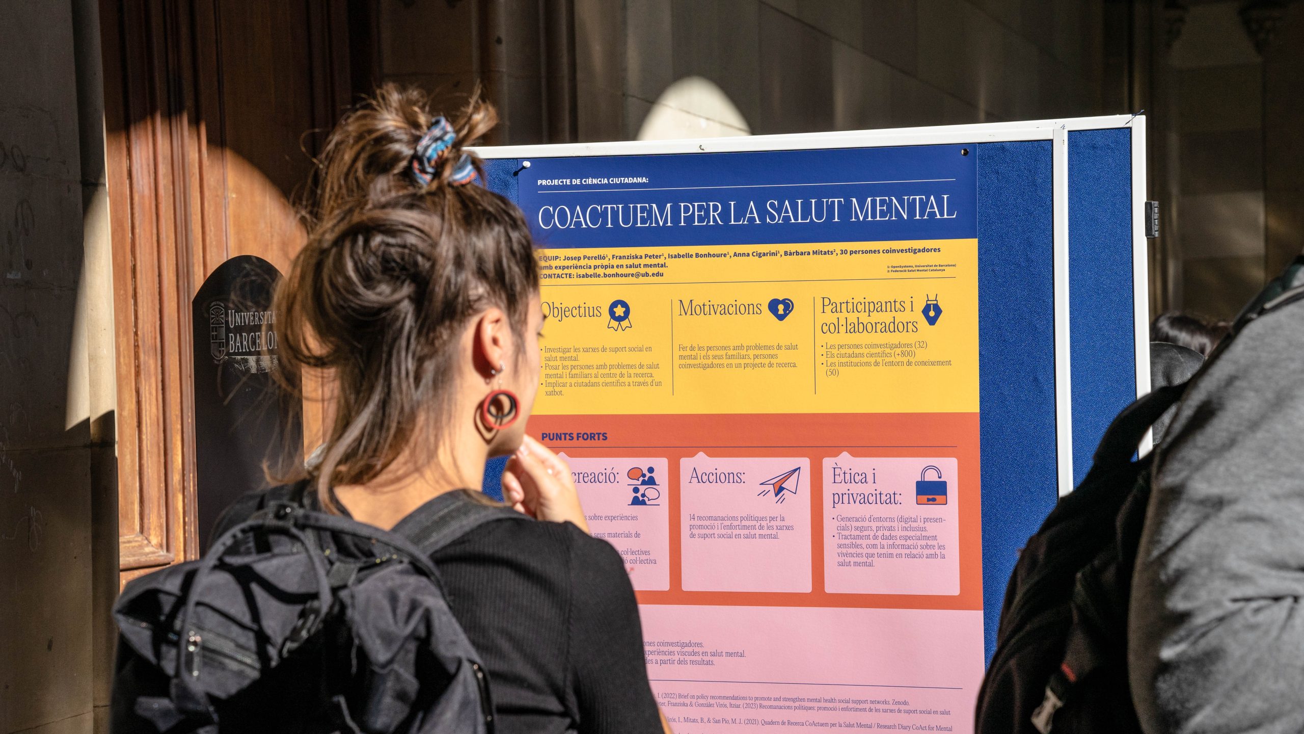 A girl reading a poster about how we can collaborate for mental health