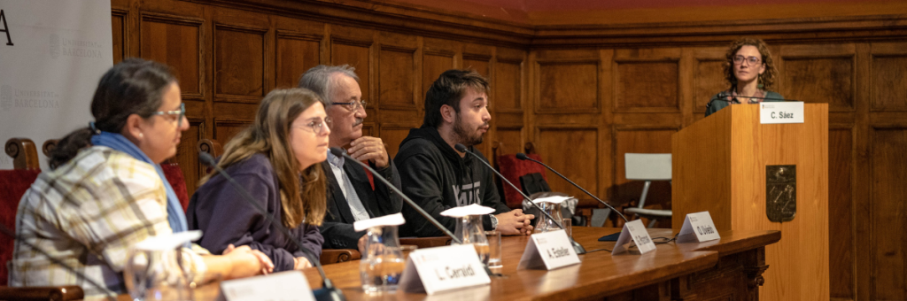 4 people sitting in a conference table talking about Citizen Science and another person standing up in the podium next to the table.