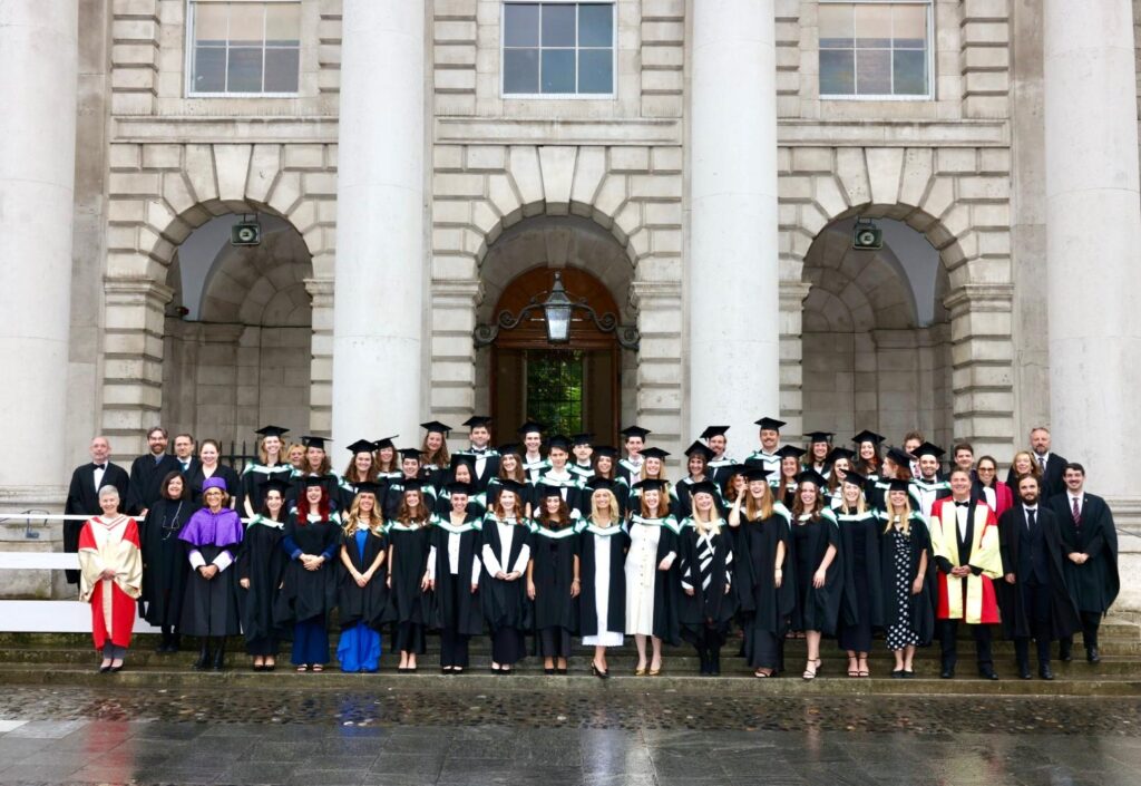 A group of graduates and academics stand together after a graduation ceremony in Trinity College Dublin