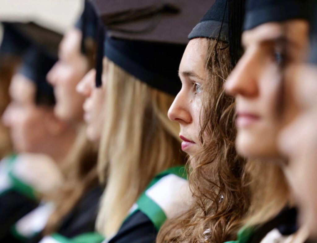 Several graduates wait to receive their degrees