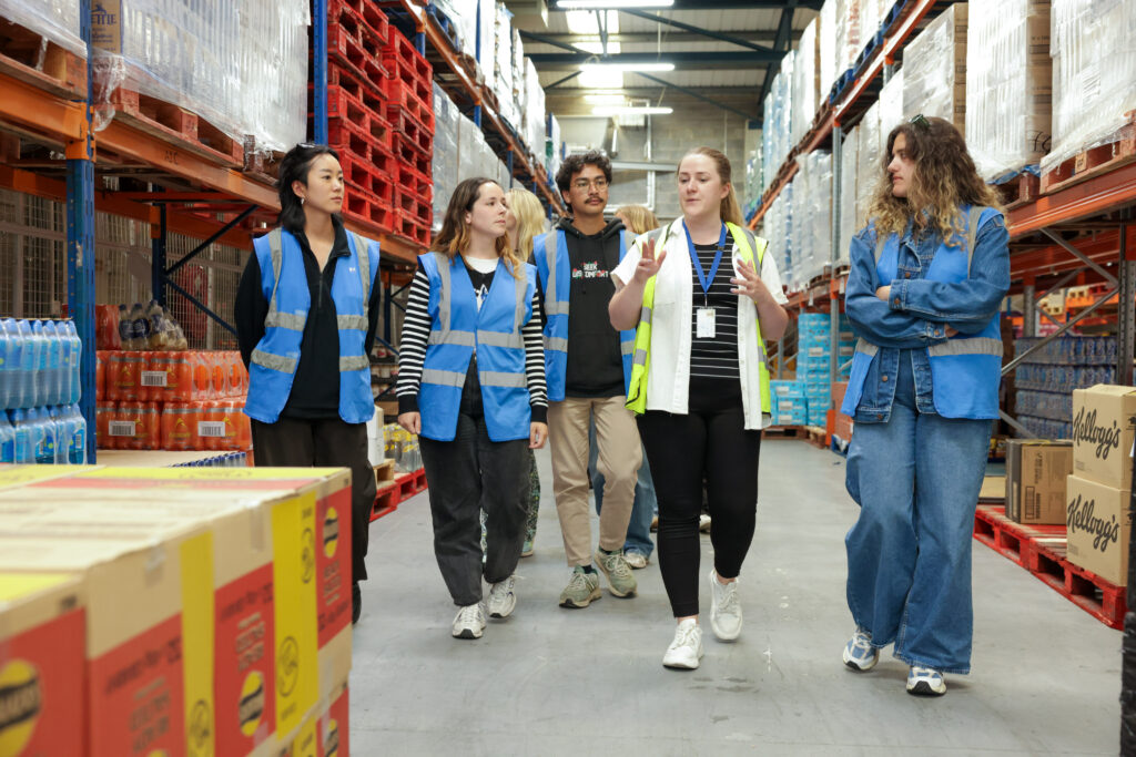 A group of people walks through a warehouse