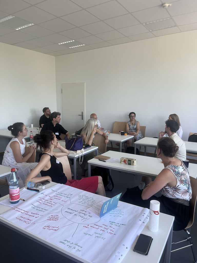 Participants seated in a classroom discussing ideas during a collaborative workshop session.