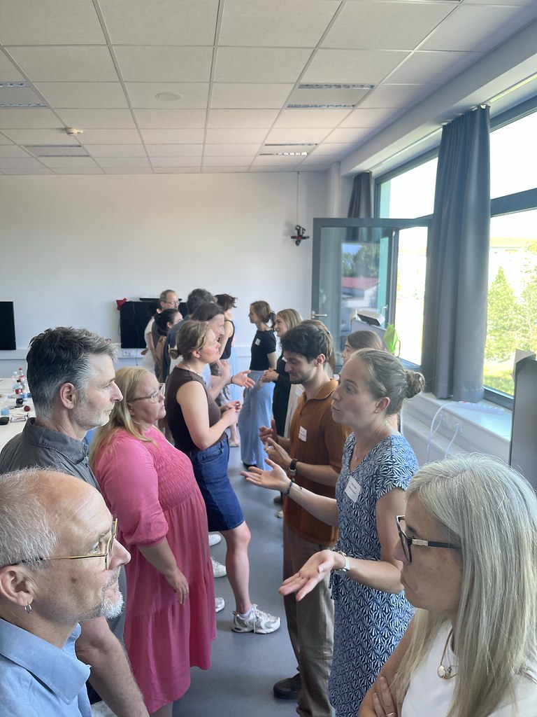 Participants engaged in paired discussions during a networking activity in a workshop setting.
