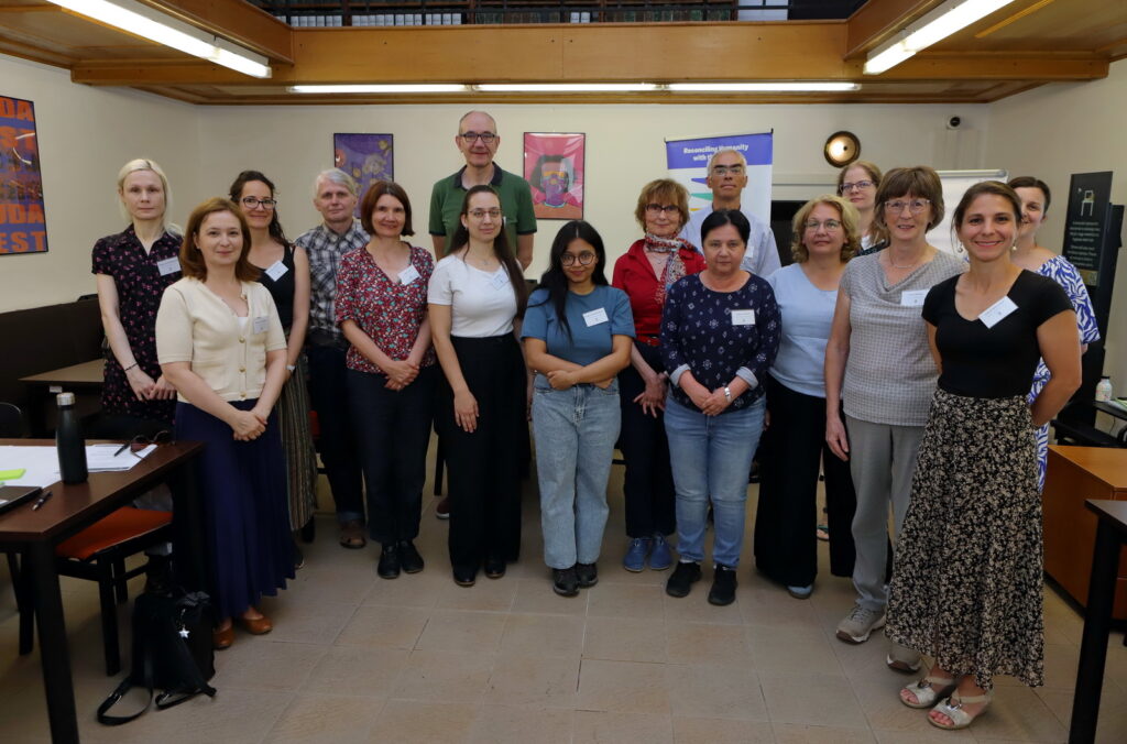 Large group of workshop participants posing together in a classroom setting.
