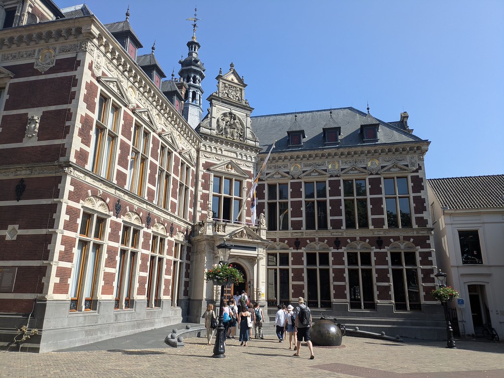 Group of people entering a historic university building in Utrecht. 