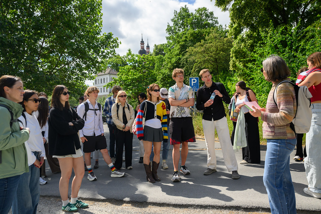 Students gathered outdoors during a guided field visit, listening to a presentation.