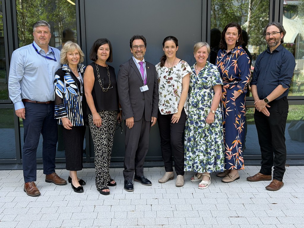 Group of CHARM-EU representatives posing for a photo outside a modern university building during the 4th Forum of the European Universities Initiative.
