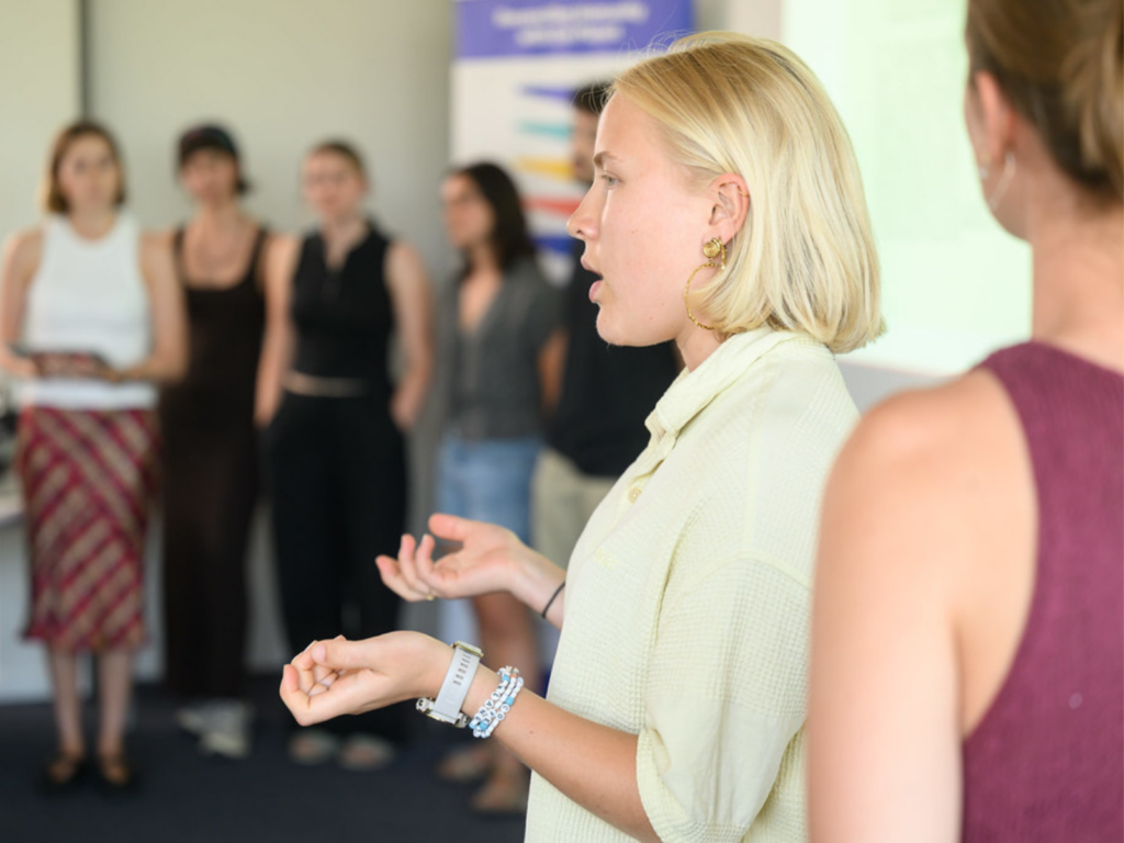 a photo of a student presenting to a small group.
