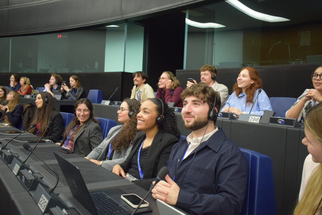 Participants wearing headsets seated in the European Parliament chamber during plenary session of the ESA26.