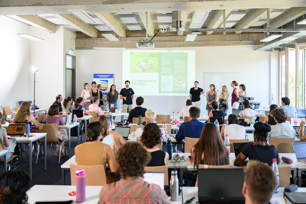 Participants presenting a project to a classroom audience during a CHARM‑EU learning session.