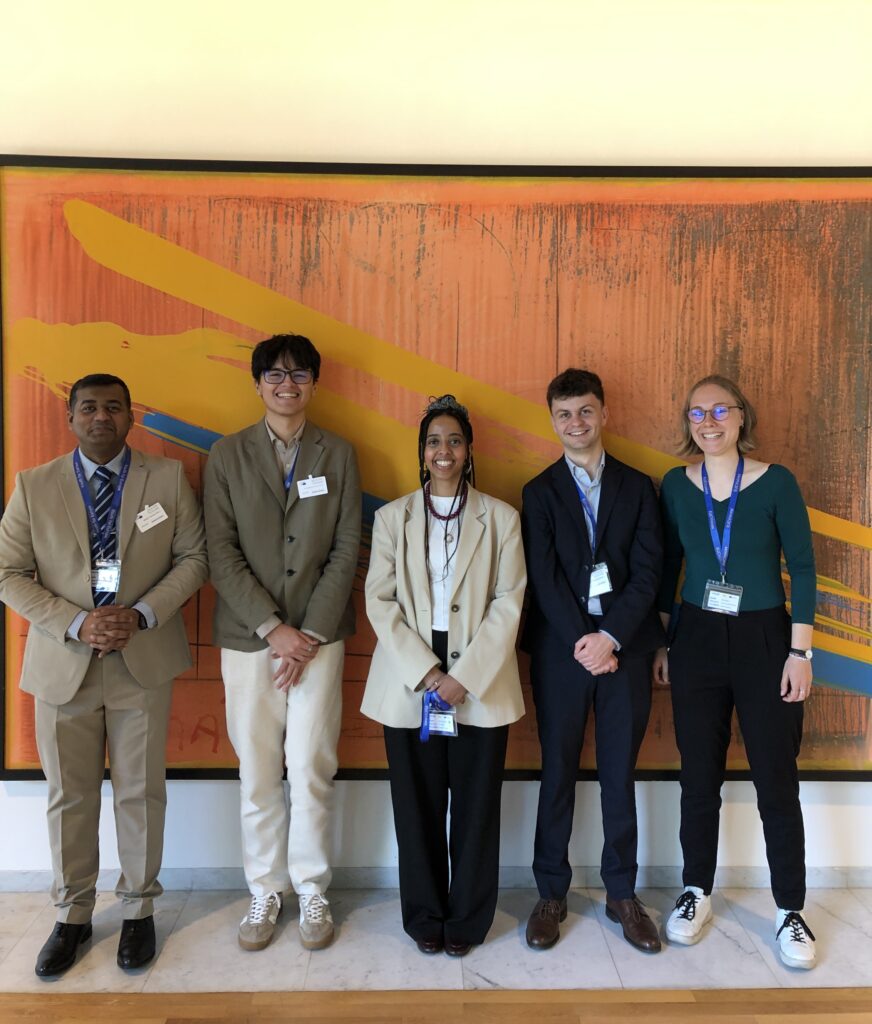 Group of participants posing in front of a large abstract artwork during ESA26 at the European Parliament .


