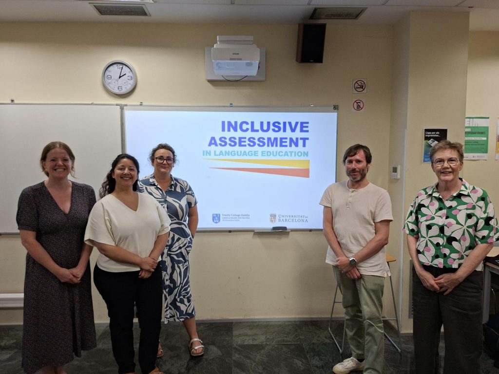 Group of participants posing in a classroom in front of a presentation titled “Inclusive Assessment in Language Education.”