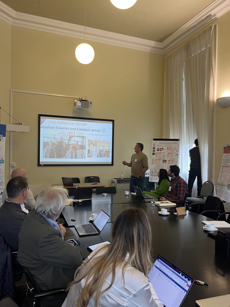 Speaker presenting to attendees in a meeting room, with a screen displaying a presentation on sustainable aviation.