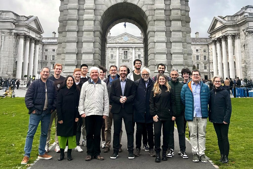 Group photo of students and staff in front of Trinity College Dublin’s historic archway during a CHARM‑EU networking event.