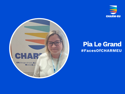 A graphic for the #FacesOfCHARMEU series featuring a circular portrait of Pia Le Grand against a solid blue background. She is a woman with blonde hair and glasses, smiling while wearing a patterned light-colored top and a lanyard, standing in front of a CHARM-EU banner. To the right of the portrait, the white text reads "Pia Le Grand" followed by "#FacesOfCHARMEU", with the multi-colored CHARM-EU alliance logo located in the top right corner.