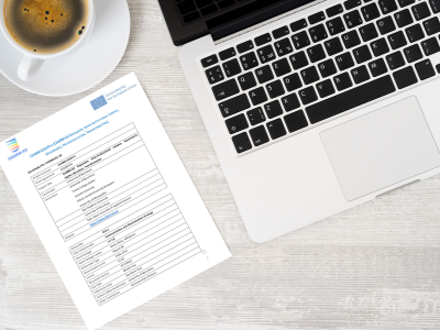 A laptop and a coffee cup on a table together with a printed deliverable from CHARM-EU